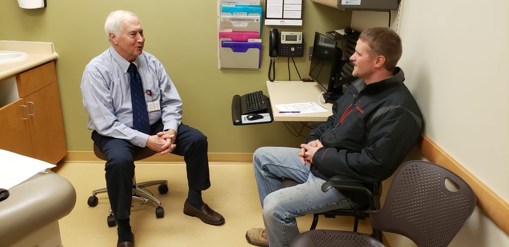Doctor consulting with patient in a medical office, emphasizing the importance of regular checkups for health and wellness at Burnett Medical Center in Grantsburg, WI.