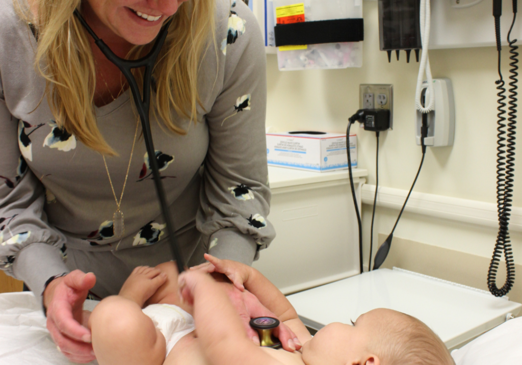 Healthcare provider examining infant during pediatric check-up at Burnett Medical Center, emphasizing preventive care for childhood health.